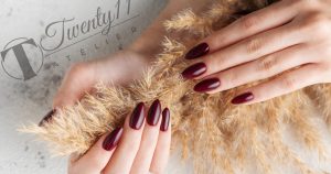 hands of a young woman with dark red manicure on